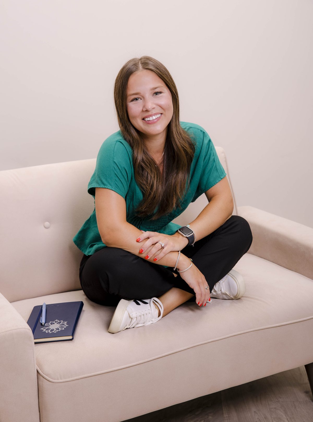Alexa DiMeglio seated comfortably on a couch with a notebook